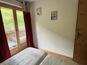 a bedroom with a window and a bed and a door at Pracondu 2 207 - OUTDOOR & FUN apartment 4 pers in Nendaz