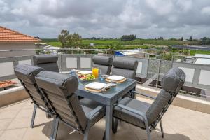 a dining table and chairs on a balcony with a view at Tel Mond Complex - וילה מקסימה למשפחות עם ג'קוזי וסוויטה in Tel Mond