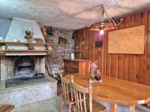 a kitchen with a wooden table and a fireplace at Vetus pontem in Vrboska