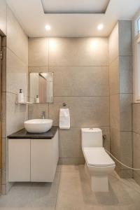 un bagno con un water bianco e un lavandino di Alaya Stays Pinnacle Hilltop 3BHK Apartment with Picturesque Balcony & Scenic Views a Barog