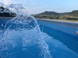 a swimming pool with water spraying into the air at Cabana Blanca Turisme Rural in Solsona