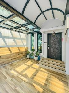 a large room with a wooden floor and glass ceilings at Flower House in Tainan