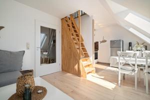 a living room with a staircase leading to a dining room at Am Golfplatz 25 Strandkrabbe in Stakendorfer Strand