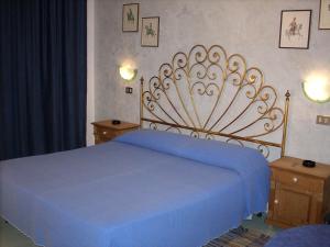 1 dormitorio con 1 cama azul y 2 mesitas de noche en Marta, en Trieste