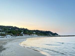 a beach with the ocean and rocks in the water at Casa Mayra in Campofilone
