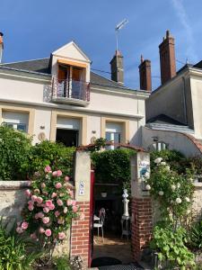 a house with a red door and flowers at Les Studios de Soizick in Amboise