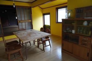 a dining room with a wooden table and chairs at トナリ in Hii