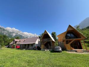 a couple of houses with mountains in the background at Villa Belinis in Theth