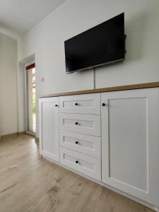 a large white dresser with a flat screen tv on a wall at Apartament Ala in Przewłoka +3 photos