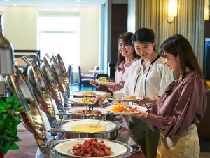 a group of women holding plates of food at Hotel Universal Port in Osaka