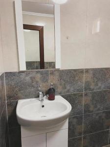 a bathroom with a white sink and a mirror at The sweet house! in Vama Veche +4 photos