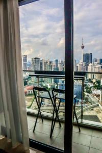 a balcony with a table and a view of a city at KL Central 33rd Floor KLCC view in Kuala Lumpur