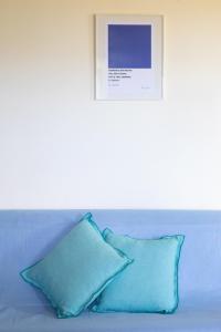 two blue pillows sitting on a couch with a picture at AGRITURISMO BUON VENTO, Appartamento PICCOLI SOLI una chic country house in Gubbio Italy in Gubbio +46 photos
