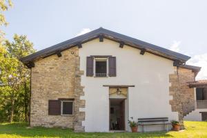 a white house with brown shutters on it at AGRITURISMO BUON VENTO, Appartamento PICCOLI SOLI una chic country house in Gubbio Italy in Gubbio