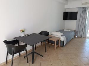a bedroom with a bed and a table and chairs at Georgia Hotel Apartments in Protaras