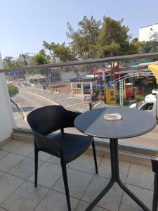 a black chair and a table on a balcony at Georgia Hotel Apartments in Protaras