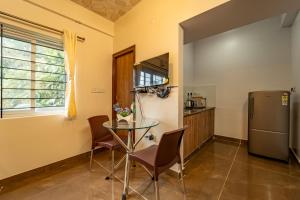 a kitchen with a glass table and a refrigerator at The Suites in Bangalore +26 photos