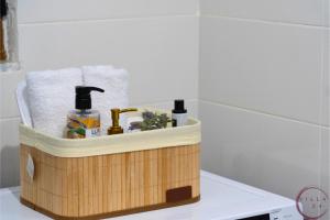 een badkamer met een houten mand met toiletartikelen erin bij VILLA 24 Sarandë in Sarandë