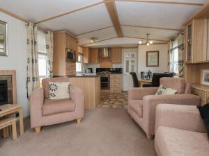 a living room with two chairs and a kitchen at Willow in Denny