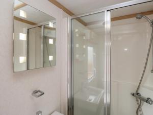 a bathroom with a shower and a mirror at Willow in Denny +21 photos