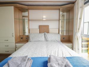 a bedroom with a bed with wooden cabinets at Willow in Denny