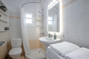 a white bathroom with a toilet and a sink at Caruana Living in Agia Anna Naxos +24 photos