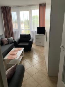 una sala de estar con un sofá y una mesa en Apartament "Na fali", en Jarosławiec