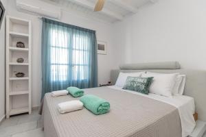 a bedroom with a large bed with towels on it at Caruana Living in Agia Anna Naxos