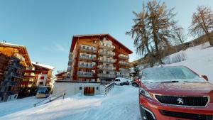 a car parked in the snow in front of a building at Pracondu 2 302 - OUTDOOR & FUN apartment 4 pers in Nendaz