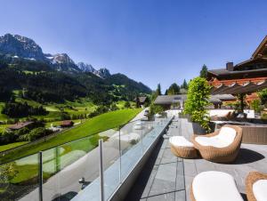 格施塔德Hôtel de Rougemont & Spa的山景阳台,配有椅子。