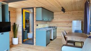 a kitchen with wooden walls and a table and a refrigerator at Belen lodge nature in Eskiömerler +5 photos