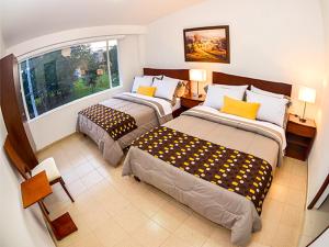 a hotel room with two beds and a window at Hotel Fontanar Usaquen in Bogotá