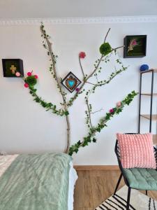 a branch with flowers on a wall next to a bed at L'Eden - Premium Suite - Vue - Balcon in Lourdes
