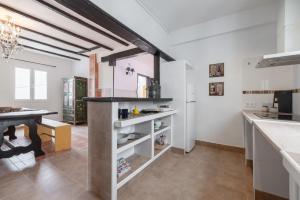 a kitchen with white walls and a table and a refrigerator at Casa Lindo in Aldover