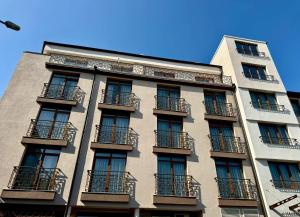 a tall building with balconies on the side of it at Hotel Luxor in Burgas City