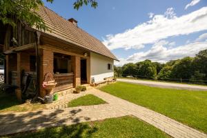 une maison avec une cour herbeuse à côté d'un bâtiment dans l'établissement Tourist Farm Rajšp, à Benedikt v Slovenskih Goricah