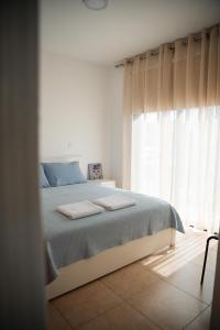 un dormitorio con una cama y una ventana en Villa Lela, en Paralimni
