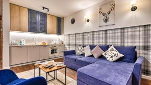 a living room with a blue couch and a table at Karpacz Residence, Sun & Snow in Karpacz