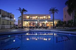 a house with a swimming pool at night at Bellos Hotel Apartments in Hersonissos