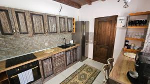 a kitchen with wooden cabinets and a sink at Casa cu Moara in Râșca