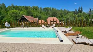 a swimming pool with chairs and a gazebo at Casa cu Moara in Râșca