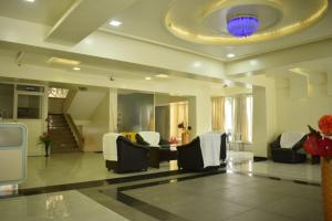 a lobby with a waiting room with chairs and a ceiling at Happy Homely Stay Hotels in Pune
