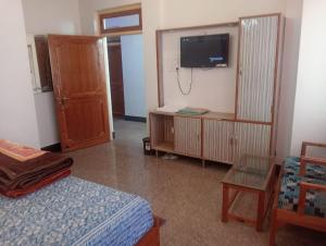 a bedroom with a bed and a tv on the wall at Hotel Ratnouday in Kāndi +27 photos