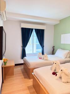 a bedroom with two beds with stuffed animals on them at Nantra de Comfort in Bangkok +45 photos