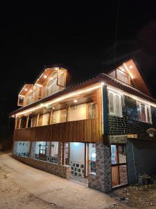 a building with lights on top of it at night at Deodar Homestay Dakbangla-kufri in Shimla