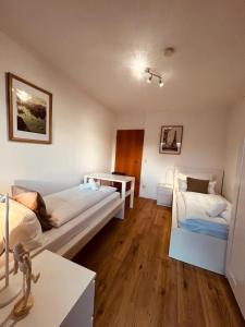 a room with two beds and a table in it at Osnabrücker Strasse Wooon 10 Einzelbetten I 5-Zimmer I TV I Bad NEU I Premiumbettwäsche in Ibbenbüren