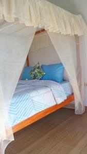 a bed with a canopy in a room at Cegeng Lestari Guesthouse in Sidemen