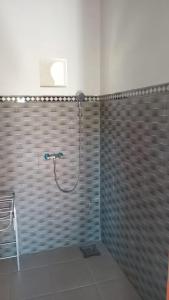 a shower with a hose in a bathroom at Cegeng Lestari Guesthouse in Sidemen
