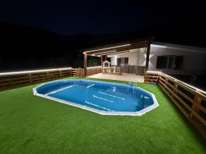 a large swimming pool on a lawn at night at Villa Aurora&Giulia in Avella