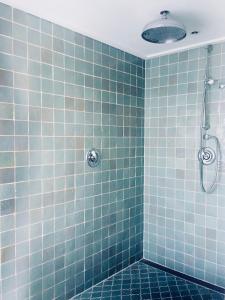 baño de azulejos azules con ducha. en Gieters Gruttertje Holiday Home, en Giethoorn 22 fotos más